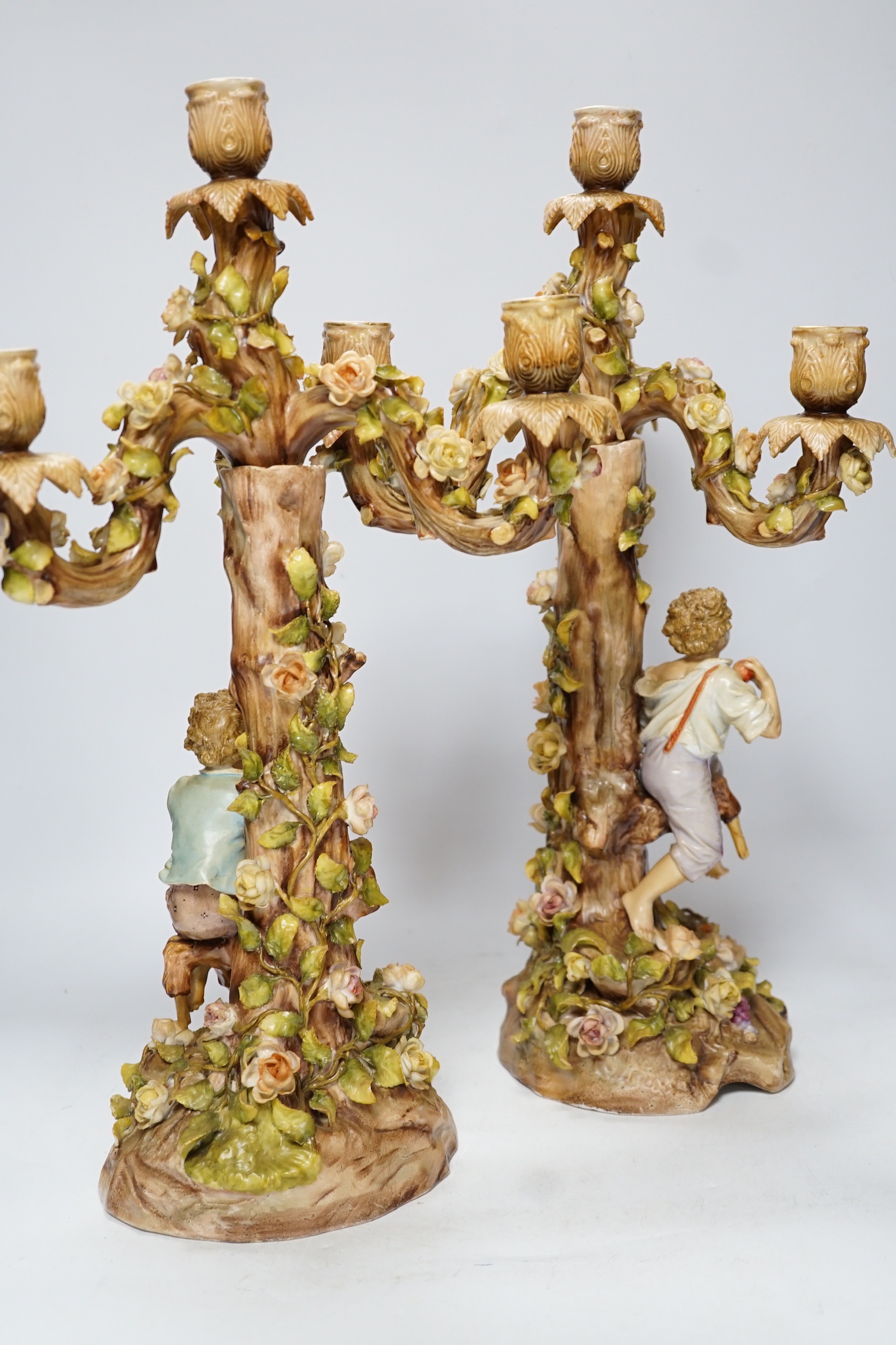 A pair of Sitzendorf / Plaue figural and floral encrusted candelabra, 47cm high